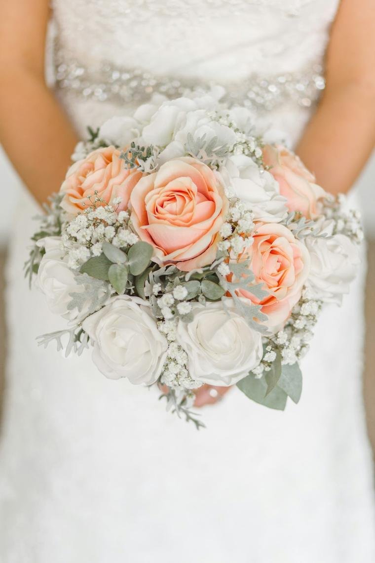 Bride holding a peach rose bouquet